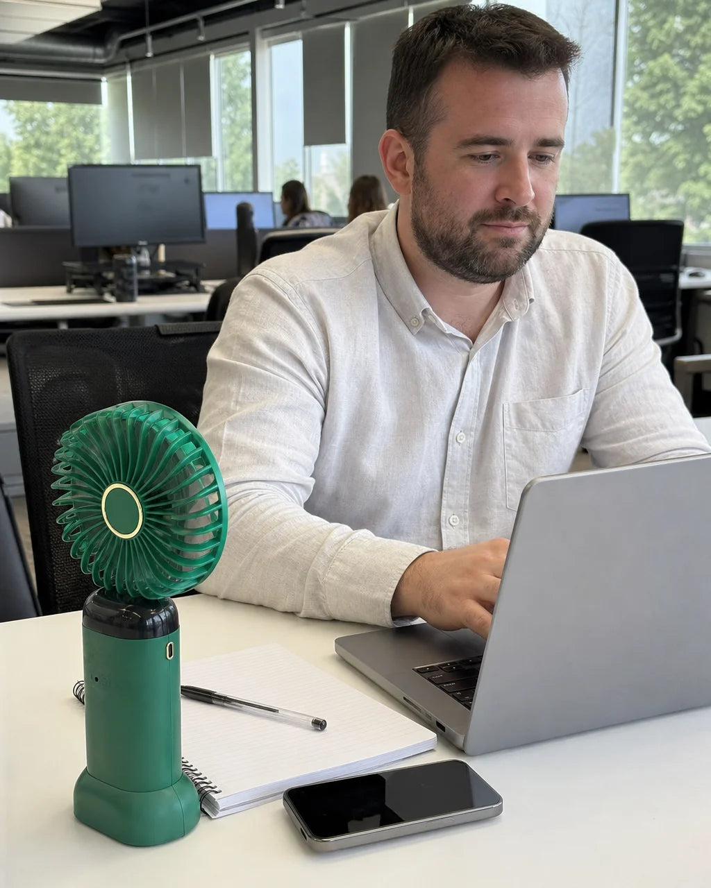 Portrait candid everyday-use photograph of the exact AirZen fan during a work session in a modern op
